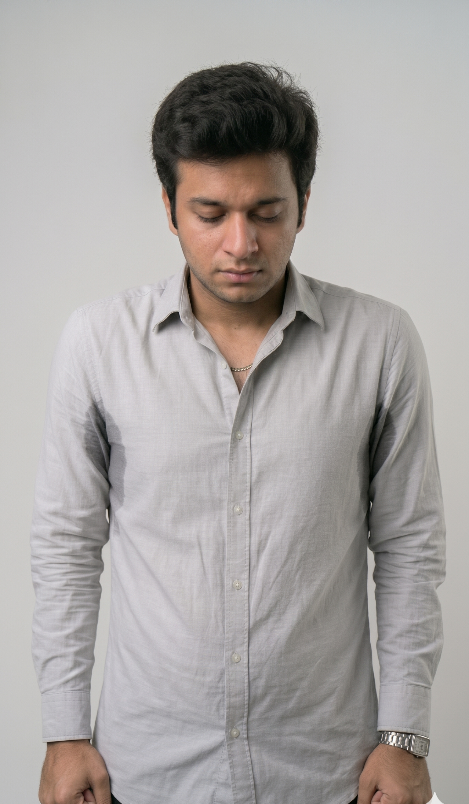 Man keeping arms down with sweat stains in underarms